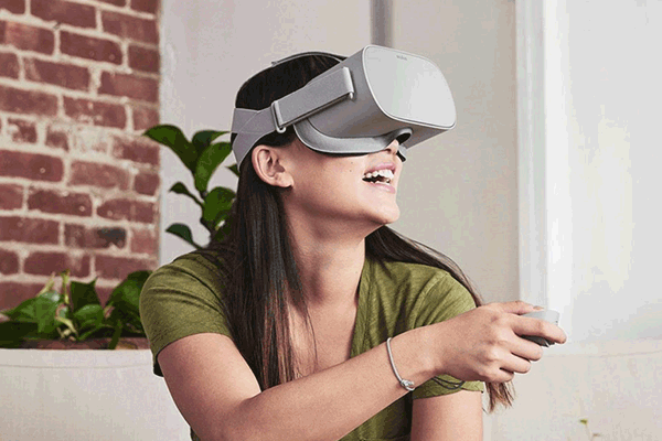 Eine Frau benutzt eine VR-Brille und taucht damit in virtuelle Welten.